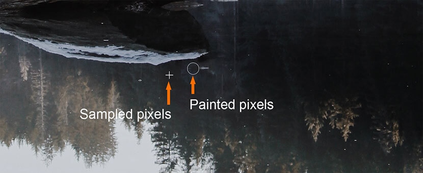 Cleaning up pixel artifacts with sampled and painted pixels using Photoshop's Clone Stamp Tool.