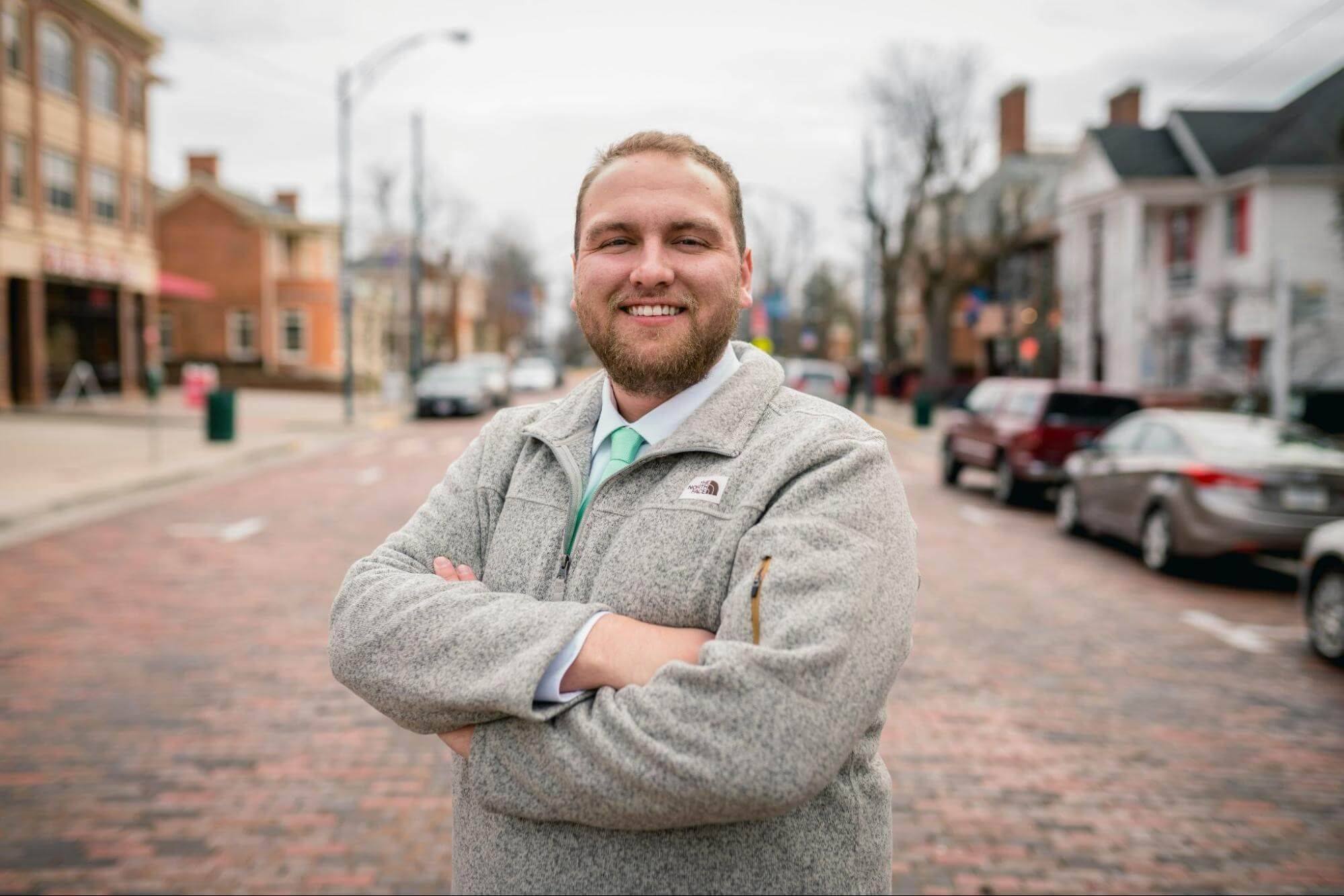 Outdoor headshot of a man in casual attire, highlighting professional headshots for branding purposes