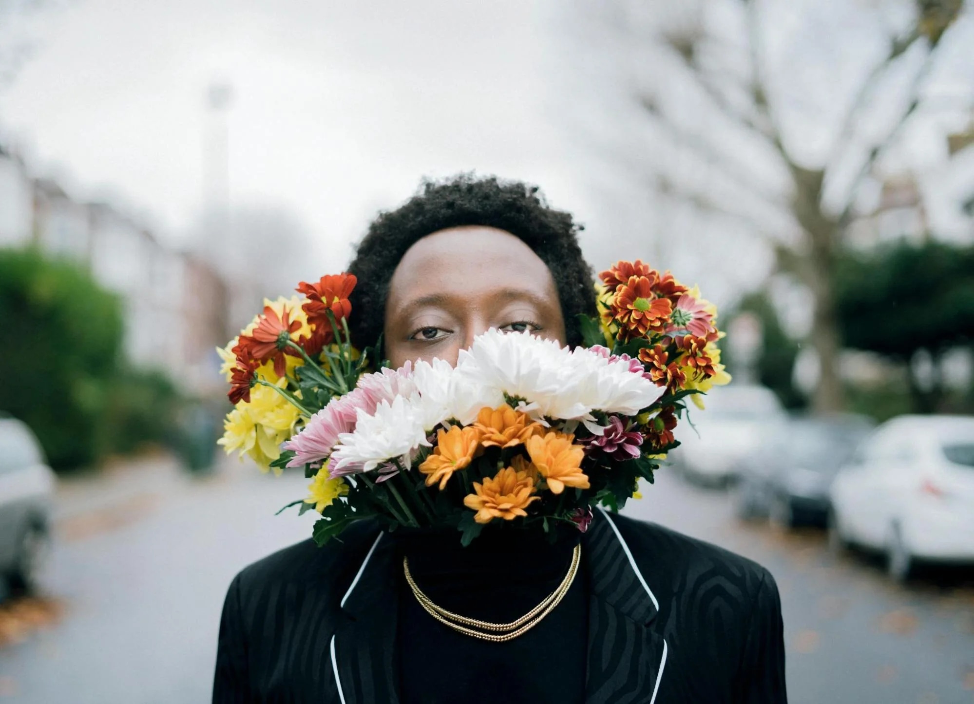 A creative fine art portrait of a person with vibrant flowers arranged around their face, blending nature and individuality.