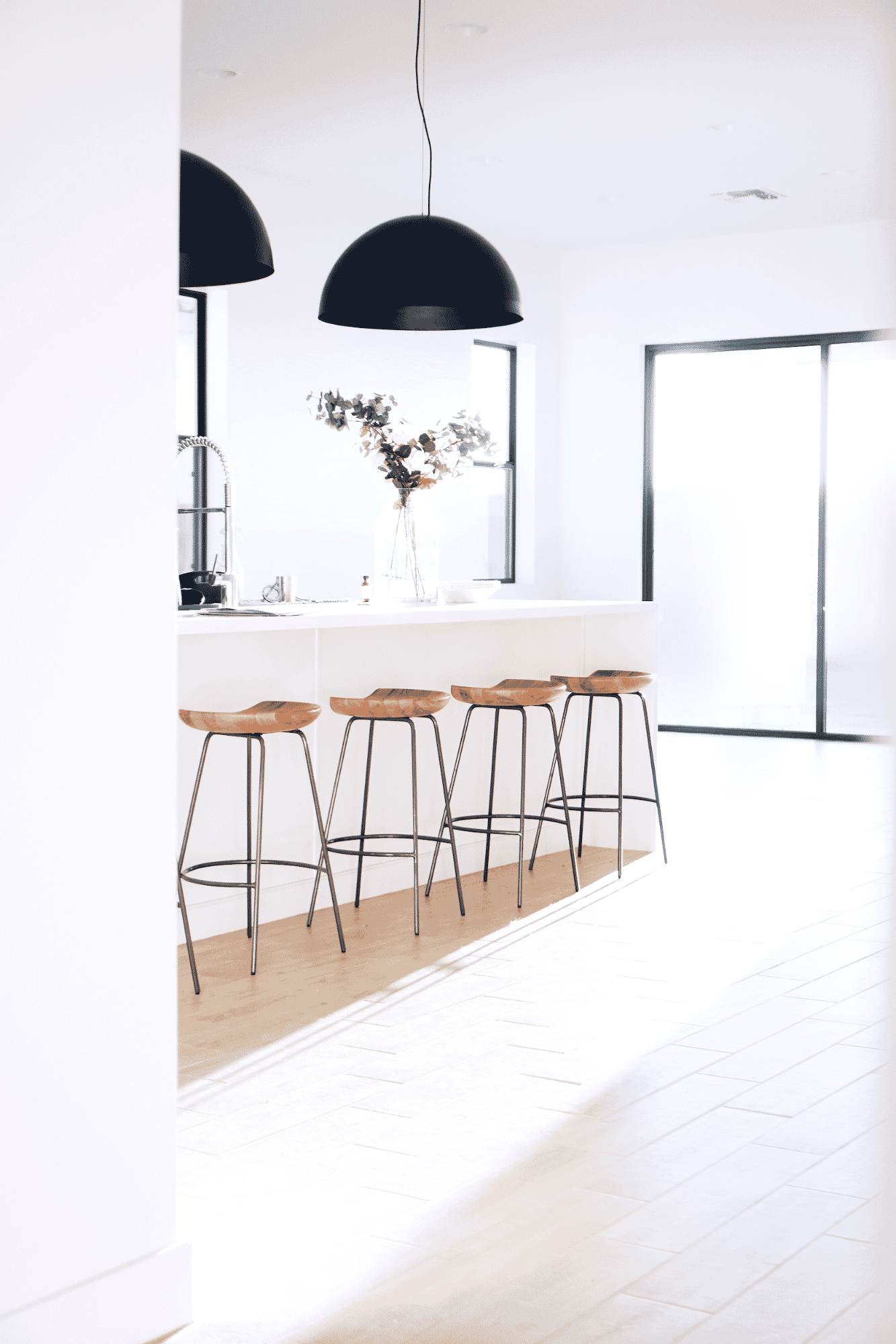 Bright and modern kitchen interior with white cabinets and wood accents.