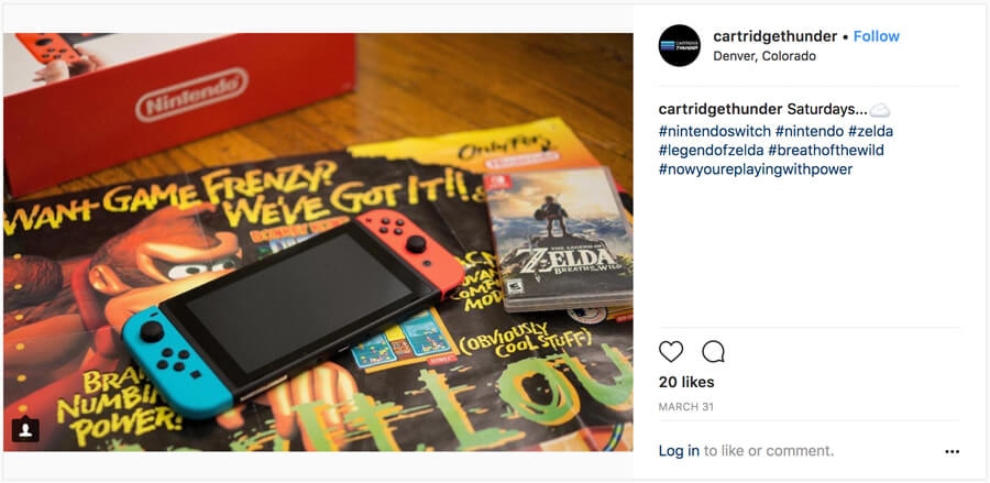 Nintendo Switch and Legend of Zelda game on tabletop with vintage gaming posters in background.