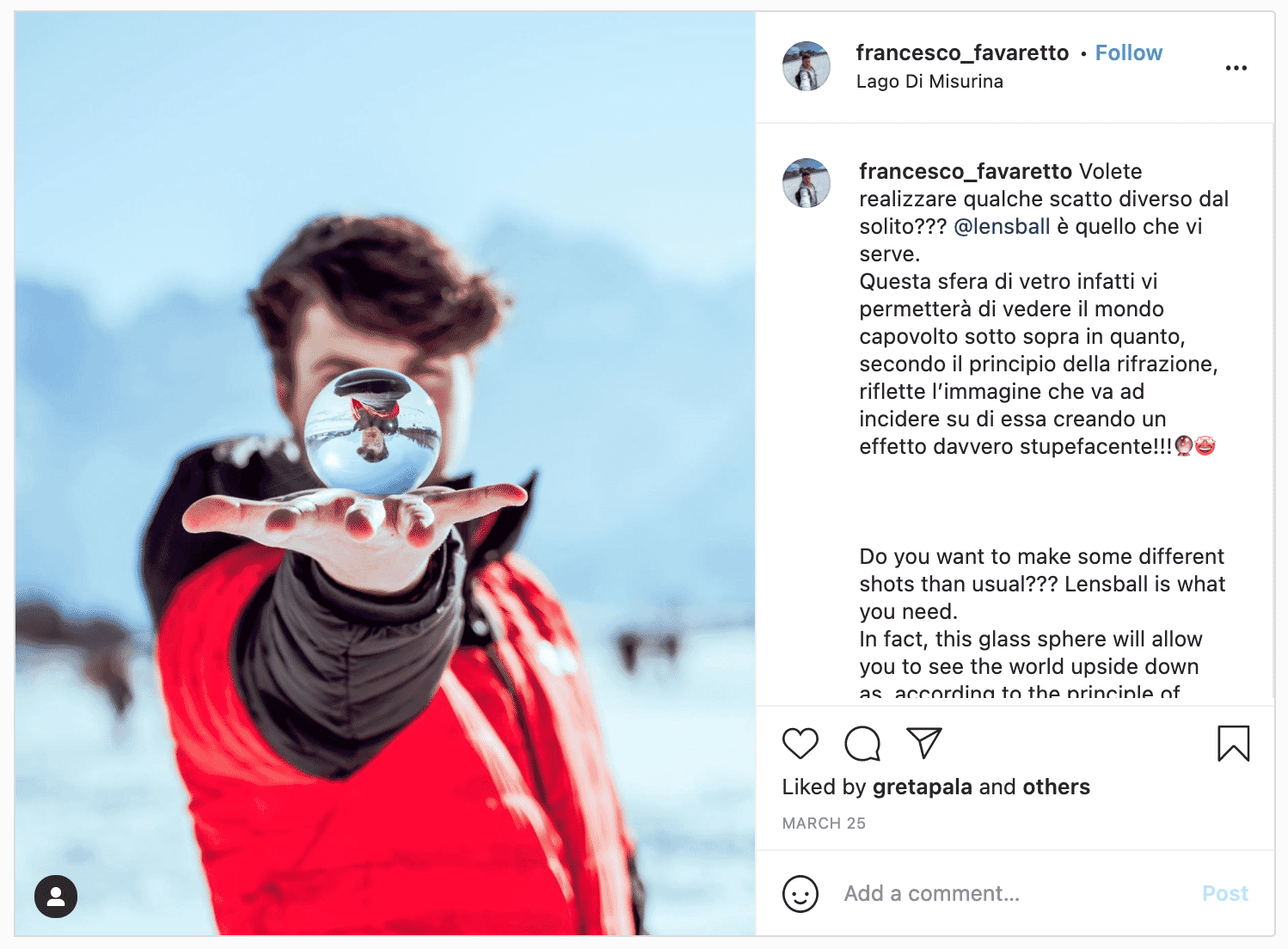 Person holding a lensball with an inverted reflection of themselves, creating a unique refraction effect against a snowy backdrop.
